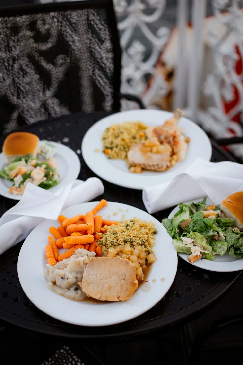 Plates from the wedding buffet with carved meat, mashed potatoes, carrots, stuffing and salad