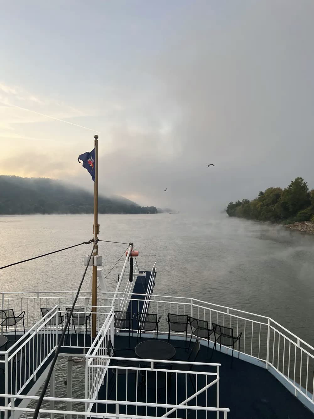 Morning fog drifting across the Ohio River and wooded hills ahead of the Queen's top deck