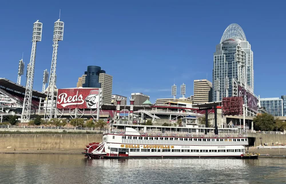 The Belle of Louisville docked in front of Great American Ball Park and the Cincinnati skyline on a sunny day