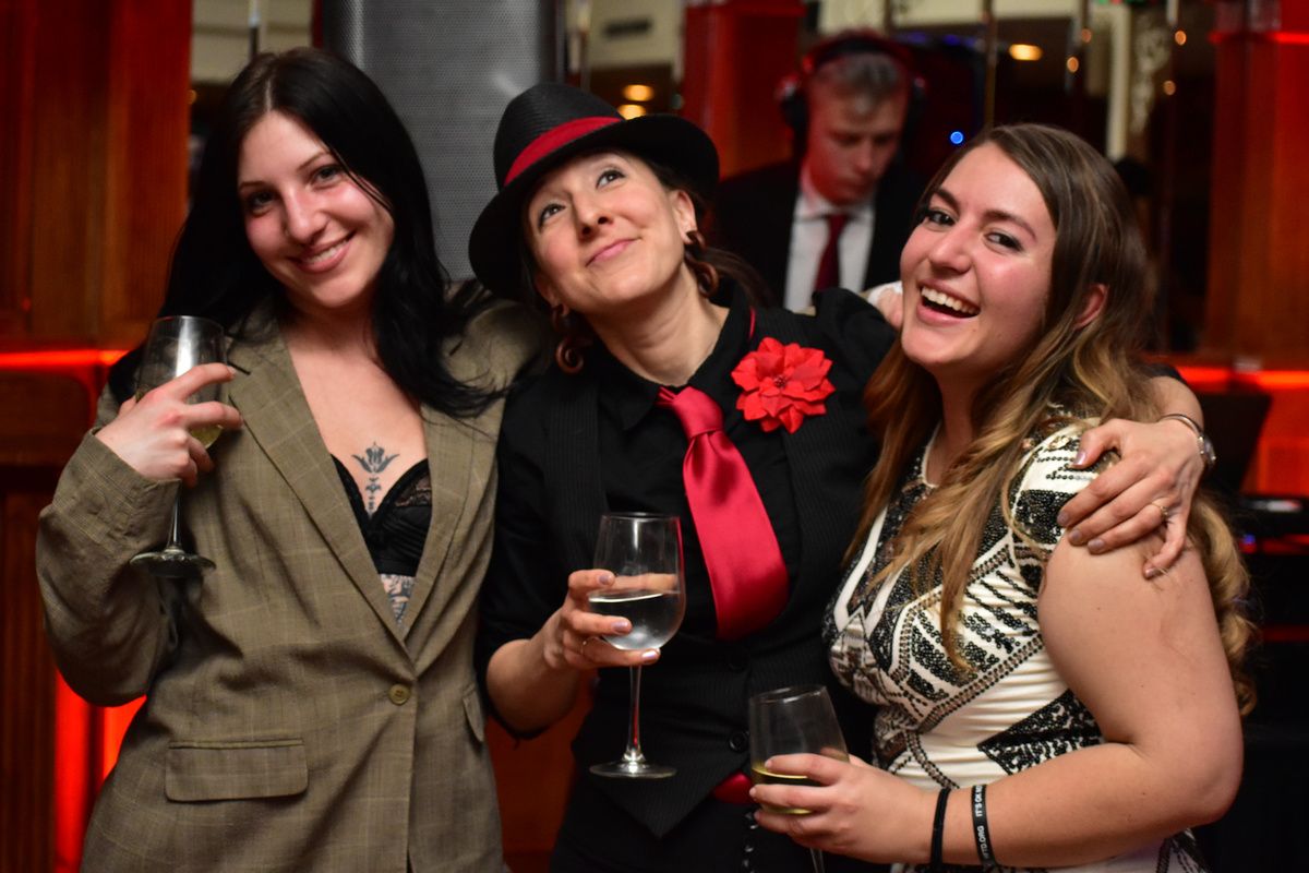Three friends in Halloween costumes raising their drinks