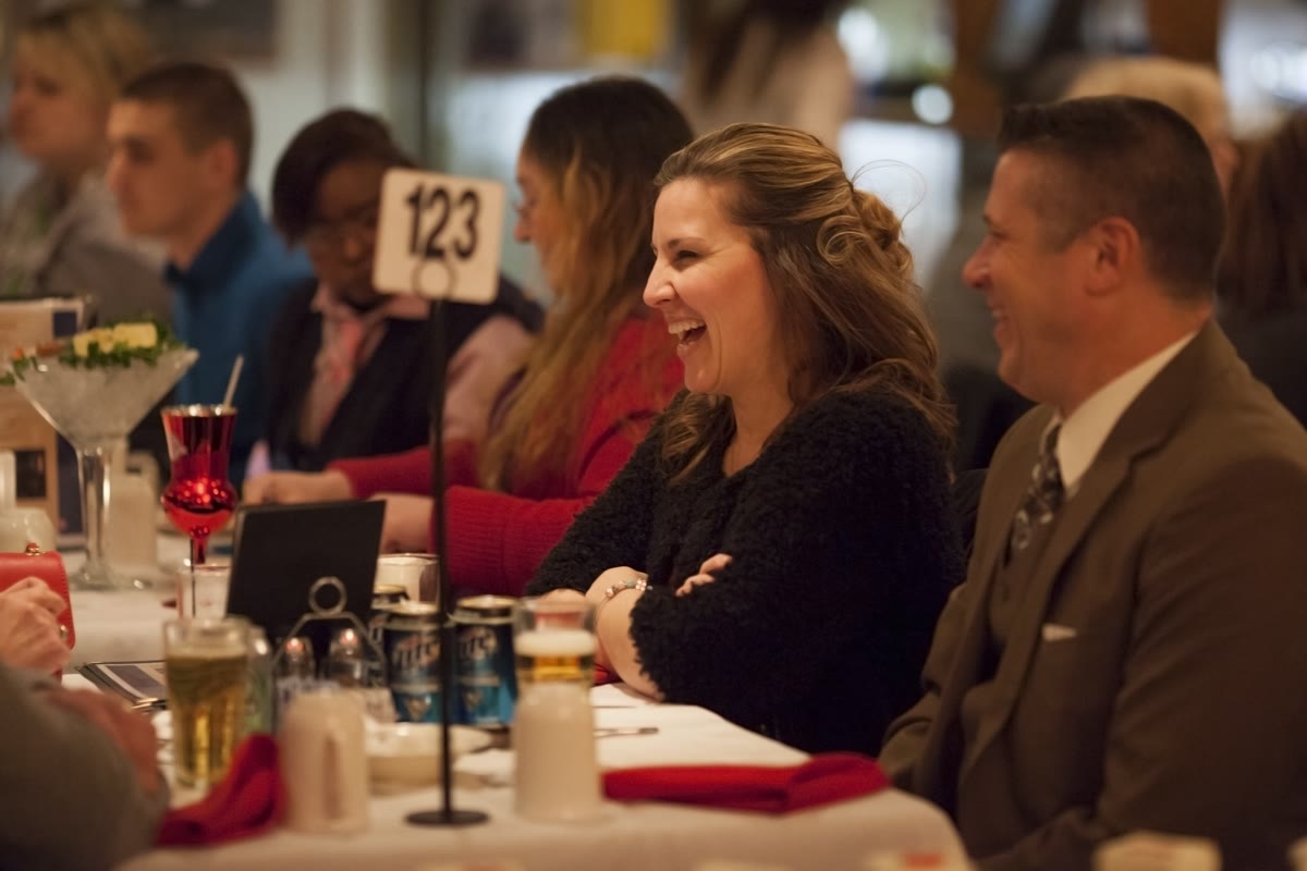 Colleagues smiling around a dinner table aboard