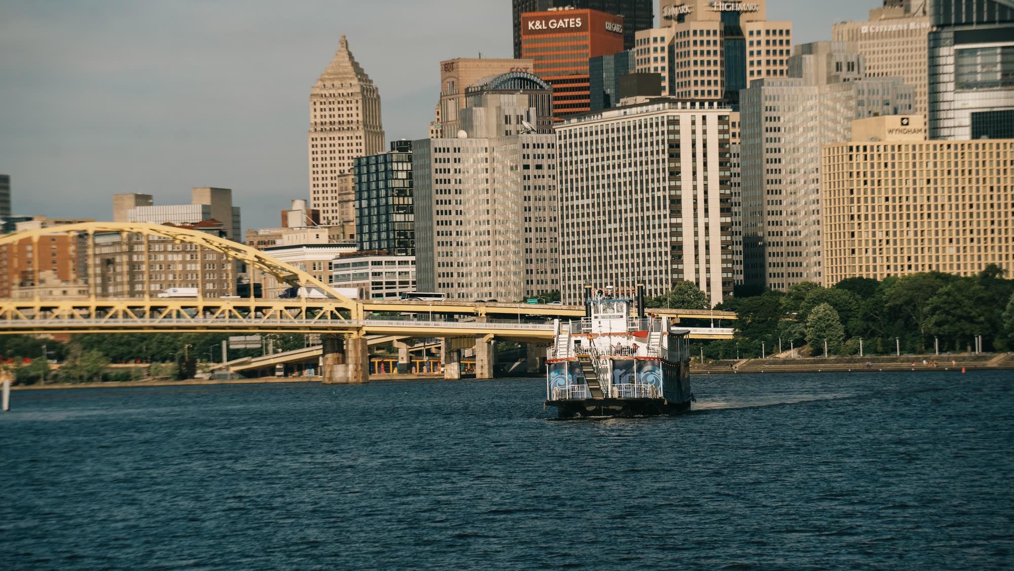 A Gateway Clipper boat full of guests passing under a yellow bridge