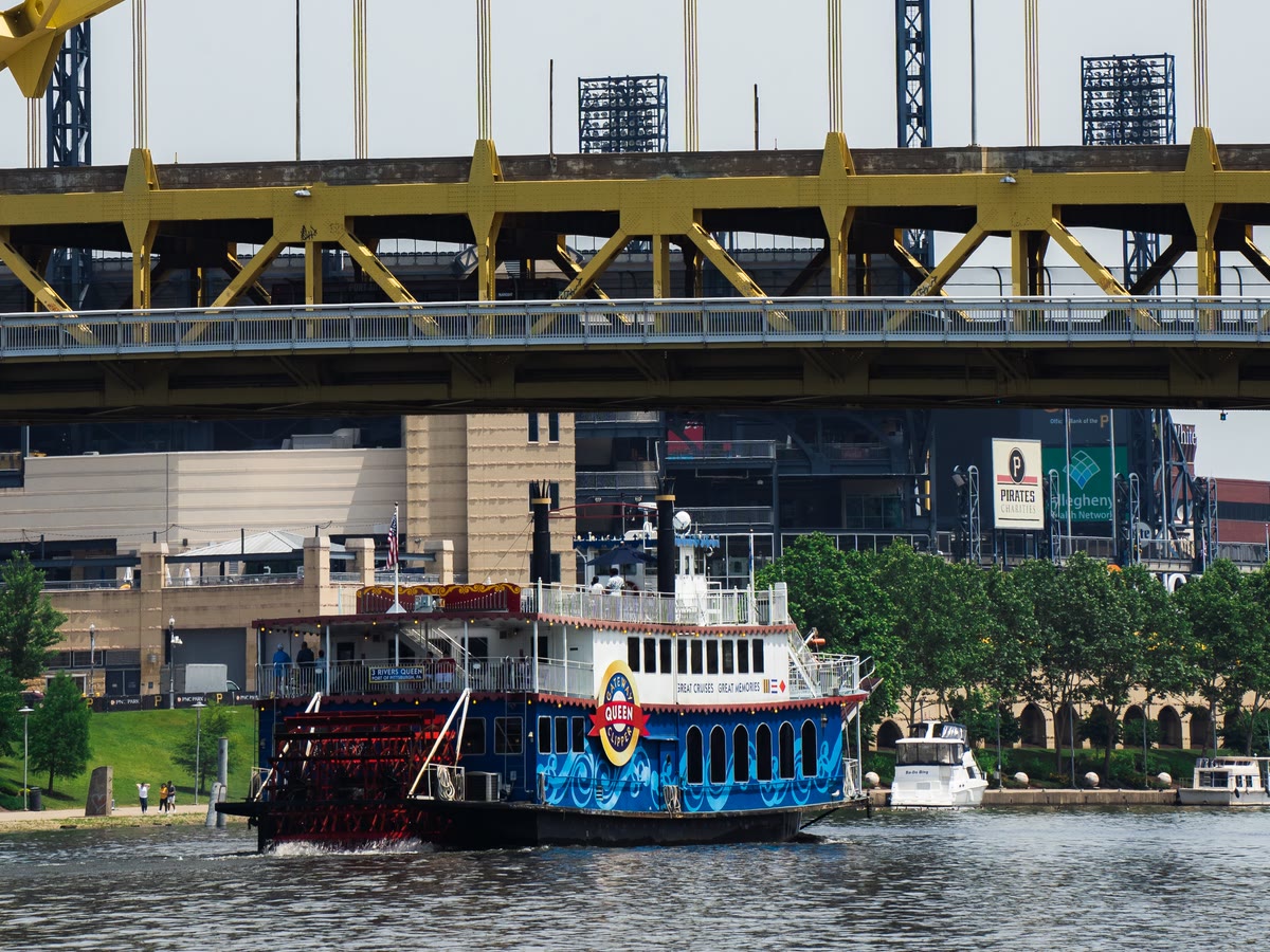 A Gateway Clipper riverboat on the Allegheny River in front of PNC Park at dusk