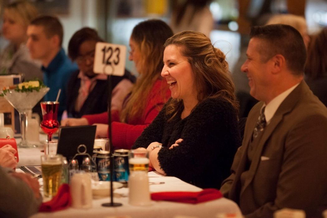 Guests laughing at a dinner table set with red napkins during a holiday cruise