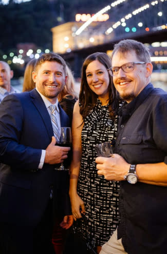 Guests with drinks at an evening event aboard