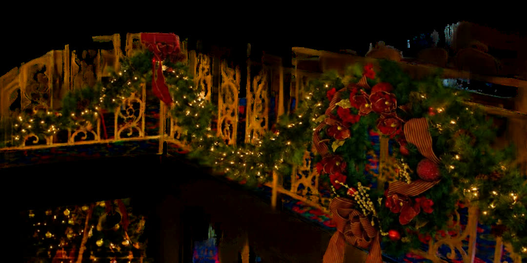 A riverboat stair rail wrapped in garland, white lights, red ribbon and a holiday wreath