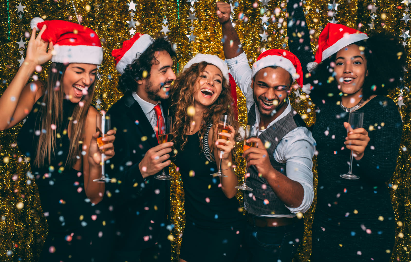 Friends in Santa hats toasting with champagne at a holiday party