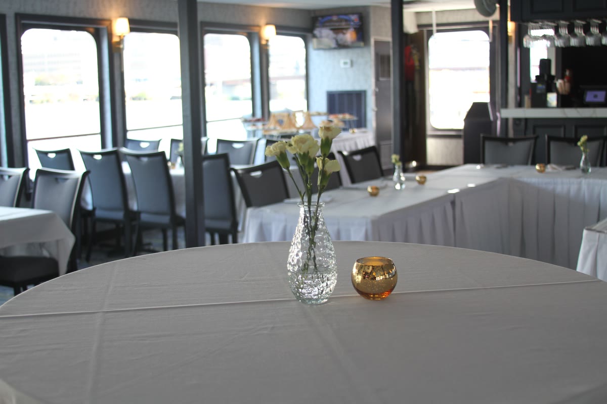 A reception-style round table set with white linen and candles
