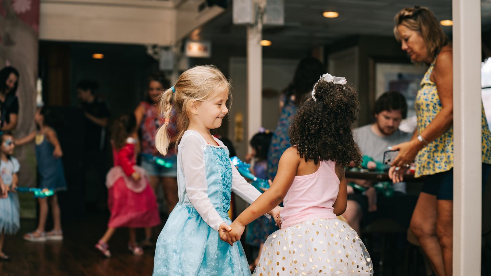 Two little girls in princess dresses dancing together
