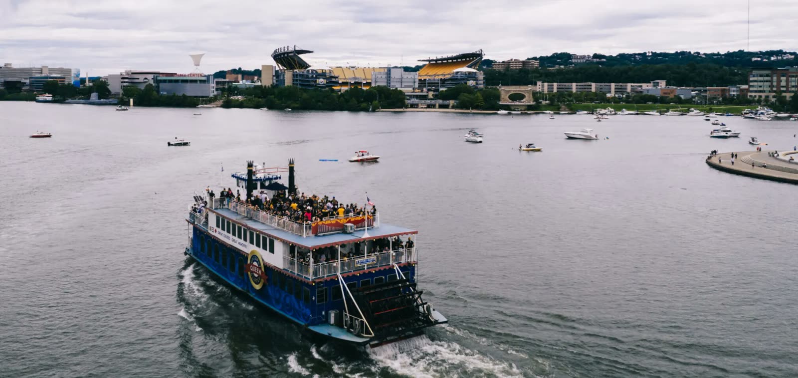 A Gateway Clipper riverboat full of fans crossing the river toward Acrisure Stadium on the North Shore