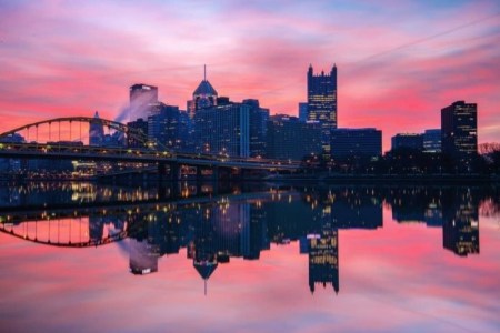 a bridge over a body of water with a city in the background