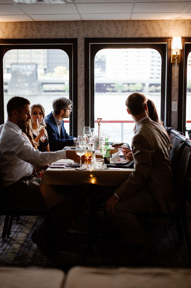 a group of people sitting at a table in front of a window